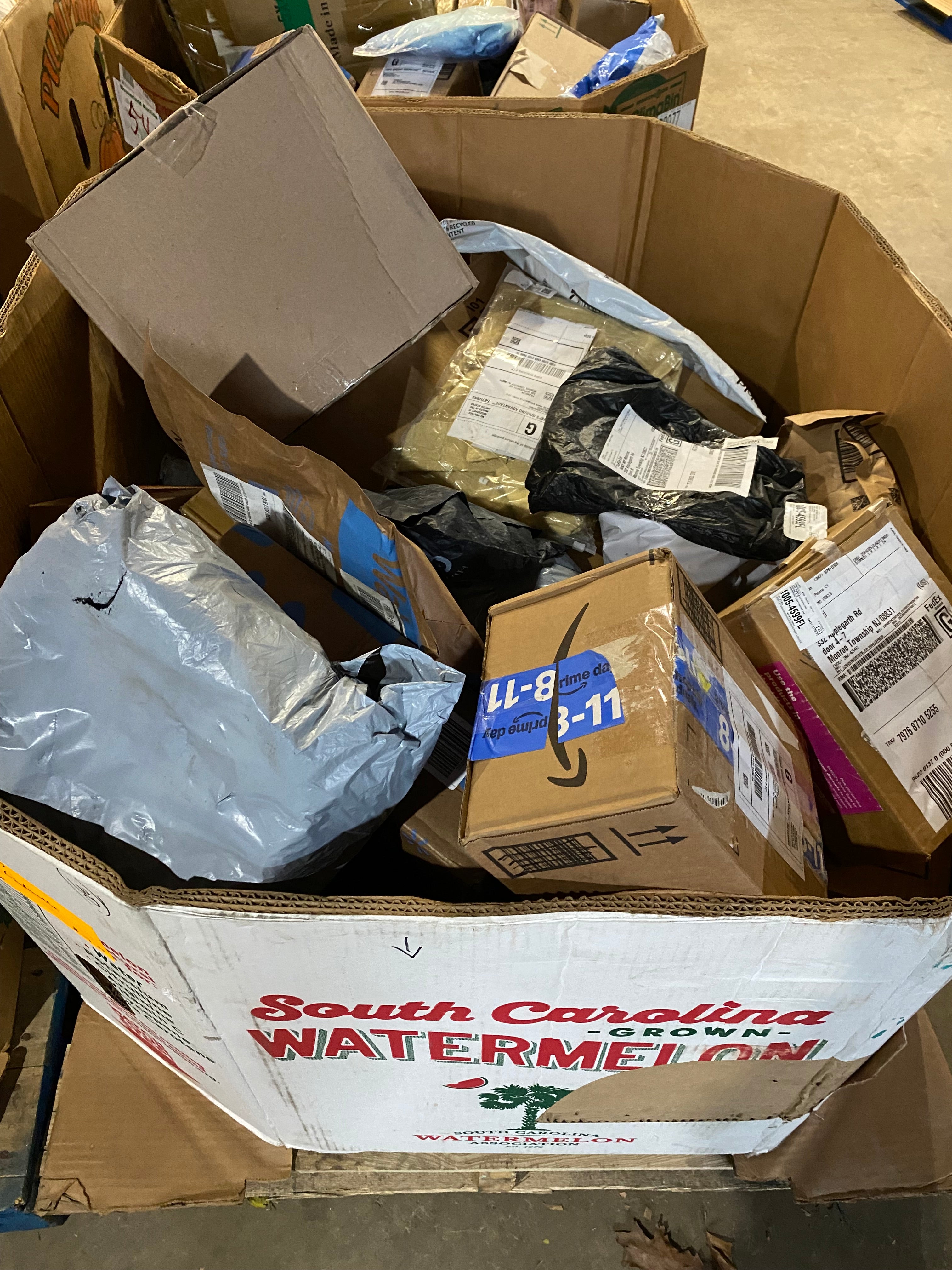 Watermelon gaylord box filled with assorted mystery mail packages and unclaimed parcels for resale, liquidation, and surprise box buyers