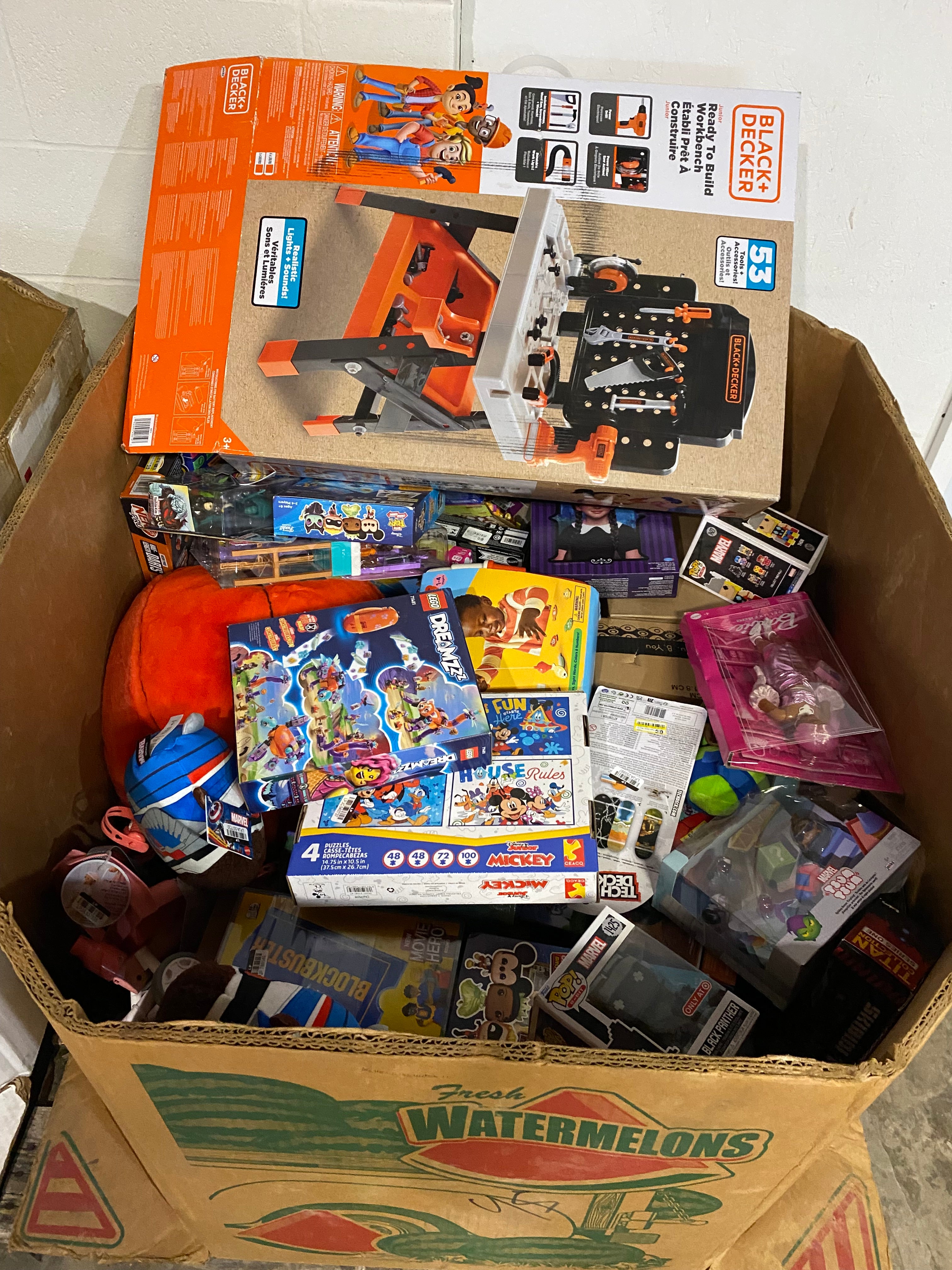 Watermelon gaylord box filled with assorted Target toys including games, dolls, and kids’ playsets for resale and liquidation buyers